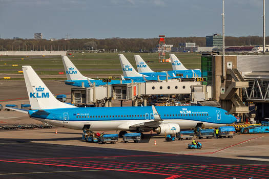 Schiphol Netherlands 16 April 2026 View of KLM Royal Dutch Airlines airplanes parked at terminal gates with ground handling equipment and workers under a clear sky. Schiphol Netherlands 16 April 2026 View of KLM Royal Dutch Airlines airplanes parked at terminal gates with ground handling equipment and workers under a clear sky.