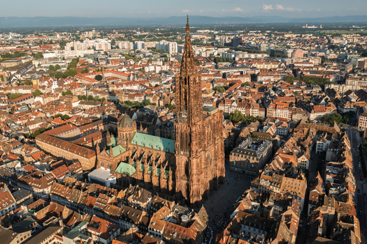 Aerial view of Cathedrale Notre Dame de Strasbourg surrounded by historic rooftops and urban architecture in Strasbourg Grand Est France.