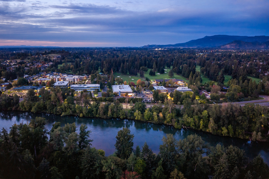 Aerial view of the Willamette River winding through lush green trees and office buildings in Eugene Oregon United States. Aerial view of the Willamette River winding through lush green trees and office buildings in Eugene Oregon United States.
