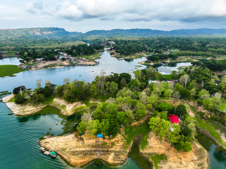 Rangamati Hill District Bangladesh 18 May 2024 Aerial view of Kaptai Lake with lush green islands calm blue water and dense forest under a cloudy sky.