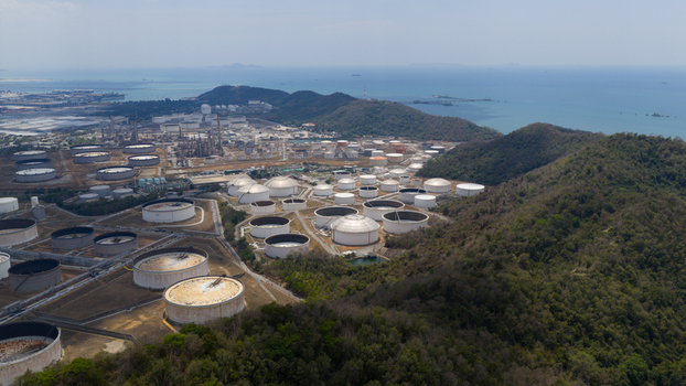 Aerial view of the Eastern Economic Corridor of Innovation EECi featuring large oil storage tanks nestled between forested hills and the coastline in Tambon Pa Yup Nai Chang Wat Rayong Thailand. Aerial view of the Eastern Economic Corridor of Innovation EECi featuring large oil storage tanks nestled between forested hills and the coastline in Tambon Pa Yup Nai Chang Wat Rayong Thailand.