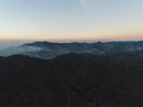 Aerial view of the Sierra de San Miguelito mountain range at dusk with visible smoke rising from the slopes in San Luis Potosi San Luis Potosi Mexico.