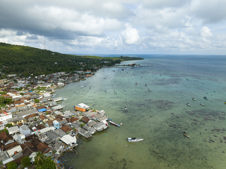 Aerial view of the village nestled along the coast where the turquoise sea meets the land a vibrant contrast of colors Karimunjawa Central Java Indonesia. Aerial view of the village nestled along the coast where the turquoise sea meets the land a vibrant contrast of colors Karimunjawa Central Java Indonesia.
