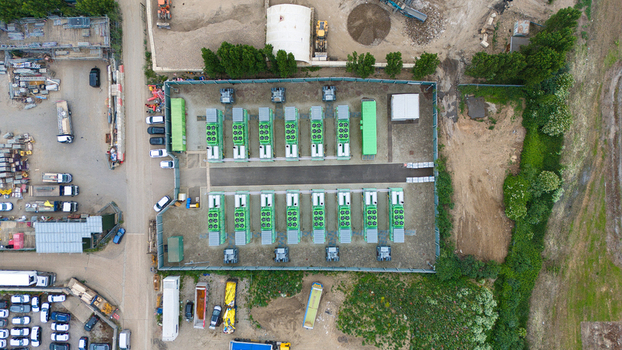 Aerial view of Damhead Creek Power Station Battery Energy Storage Systems BESS with green units arranged in rows within a fenced industrial site Rochester England United Kingdom. Aerial view of Damhead Creek Power Station Battery Energy Storage Systems BESS with green units arranged in rows within a fenced industrial site Rochester England United Kingdom.