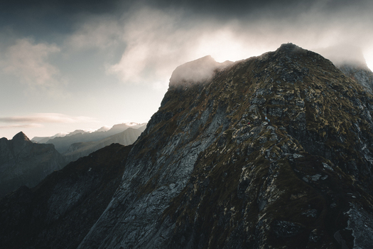 View of the rugged mountain ridge of Reinebringen with dramatic clouds and rocky slopes in Moskenes Nordland Norway.