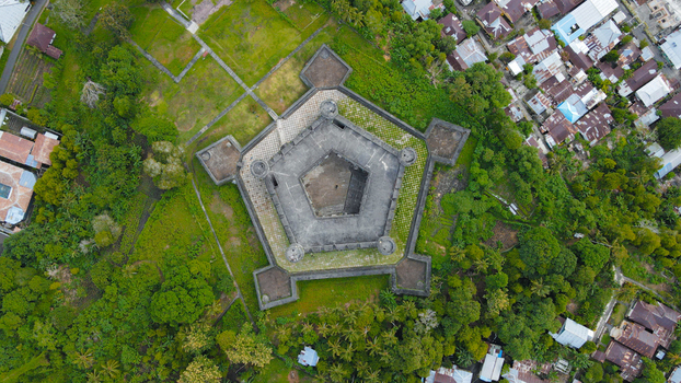 Aerial view of Fort Belgica a historic pentagonal fortress surrounded by lush greenery and nearby residential buildings in Indonesia. Aerial view of Fort Belgica a historic pentagonal fortress surrounded by lush greenery and nearby residential buildings in Indonesia.