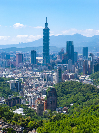 Aerial view of Taipei 101 towering over the dense urban skyline surrounded by lush green hills and modern skyscrapers under a clear blue sky in Taipei Taipei City Taiwan. Aerial view of Taipei 101 towering over the dense urban skyline surrounded by lush green hills and modern skyscrapers under a clear blue sky in Taipei Taipei City Taiwan.