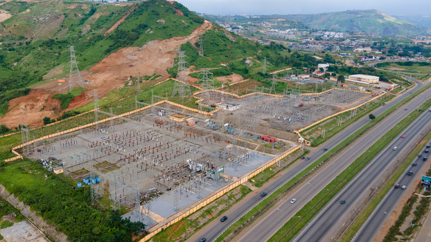 Aerial view of TCN SubStation Katampe with electrical transformers power lines and surrounding hills near a highway in Abuja Federal Capital Territory Nigeria.