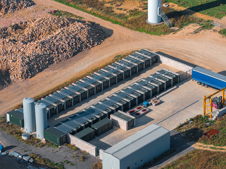 Aerial view of Chelveston Renewable Energy BESS facility featuring rows of battery storage containers industrial tanks and a truck trailer in Chelveston England United Kingdom. Aerial view of Chelveston Renewable Energy BESS facility featuring rows of battery storage containers industrial tanks and a truck trailer in Chelveston England United Kingdom.