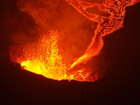 Aerial view of a powerful volcanic eruption with glowing lava flows and thick smoke rising into the night sky in Reykjavik Reykjavikurborg Iceland.
