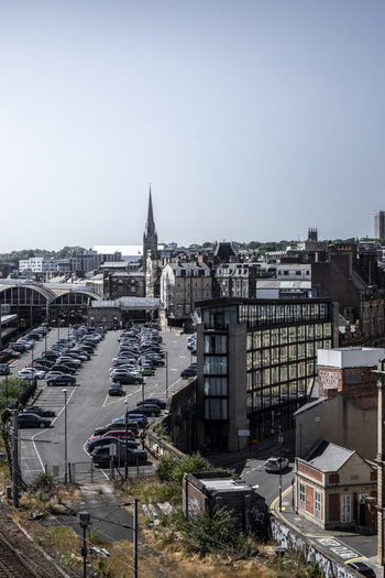 Aerial view of the Newcastle upon Tyne cityscape featuring the historic cathedral spire modern glass architecture and a busy parking lot in Newcastle upon Tyne England United Kingdom. Aerial view of the Newcastle upon Tyne cityscape featuring the historic cathedral spire modern glass architecture and a busy parking lot in Newcastle upon Tyne England United Kingdom.