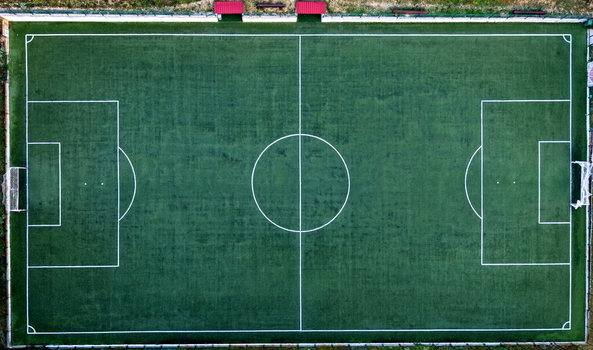 Aerial view of the soccer field at the Brzece Sports Center featuring a green artificial turf pitch with white markings surrounded by a perimeter fence in Brzece Rasina District Serbia.