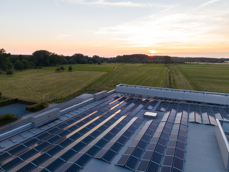 Aerial view of solar panels on a rooftop overlooking rural fields and trees during a golden sunset in Zemst Flanders Belgium. Aerial view of solar panels on a rooftop overlooking rural fields and trees during a golden sunset in Zemst Flanders Belgium.
