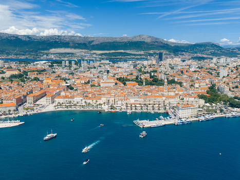 Aerial view of the historic old town and Riva promenade with boats in the harbor under a blue sky in Split Split Dalmatia County Croatia. Aerial view of the historic old town and Riva promenade with boats in the harbor under a blue sky in Split Split Dalmatia County Croatia.