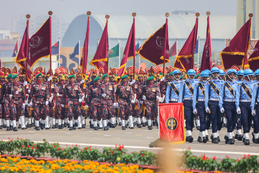 Dhaka Bangladesh 25 March 2026 View of uniformed soldiers marching in synchronized formation their maroon flags billowing against the bright sky.