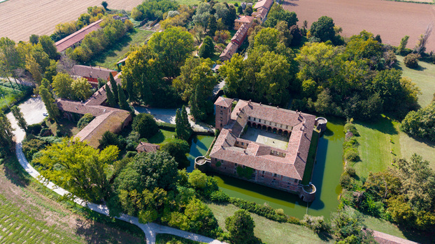 Peschiera Borromeo Italy 19 September 2026 Aerial view of Castello di Peschiera Borromeo surrounded by a moat lush gardens and historic farm buildings in the Lombardy countryside.