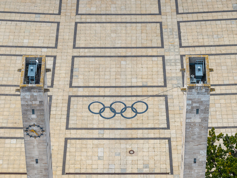 Berlin Germany 26 September 2026 Aerial view of the Olympiastadion Berlin featuring the iconic Olympic rings on the paved plaza between two tall stone towers one of which displays a clock.