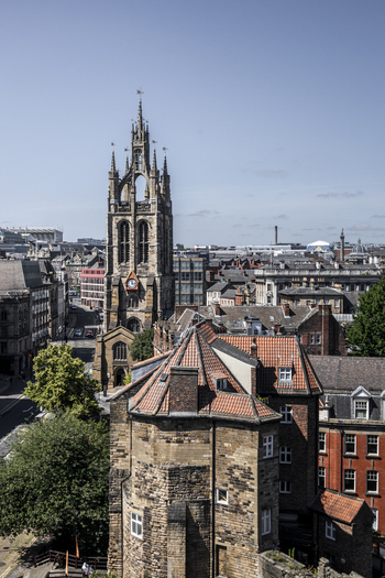 Aerial view of the historic St Nicholas Cathedral tower rising above the urban rooftops and stone buildings of Newcastle upon Tyne England United Kingdom. Aerial view of the historic St Nicholas Cathedral tower rising above the urban rooftops and stone buildings of Newcastle upon Tyne England United Kingdom.