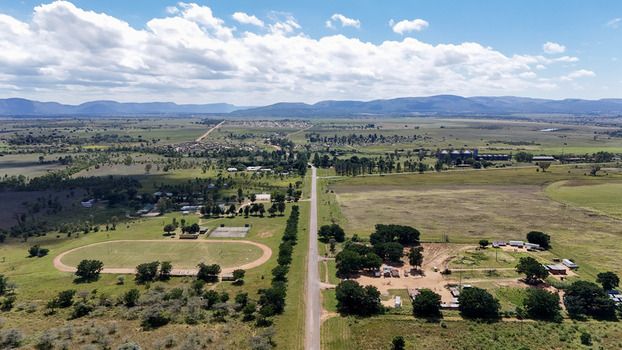 Aerial view of Alma settlement with its straight road sports field and surrounding green fields under a cloudy sky Waterberg District Municipality Limpopo South Africa. Aerial view of Alma settlement with its straight road sports field and surrounding green fields under a cloudy sky Waterberg District Municipality Limpopo South Africa.
