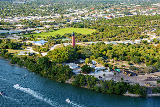Aerial view of the stoic Jupiter Inlet Lighthouse a beacon amidst the verdant landscape where the Loxahatchee River meets the sea Jupiter Florida United States.