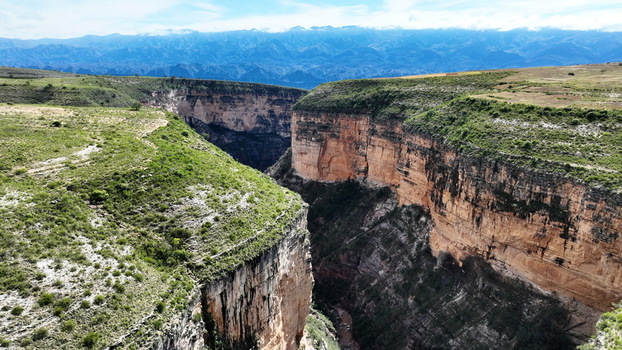 Aerial view of the dramatic El Vergel canyon featuring steep rocky cliffs lush green plateau vegetation and distant mountain ranges in Torotoro Potosi Department Bolivia. Aerial view of the dramatic El Vergel canyon featuring steep rocky cliffs lush green plateau vegetation and distant mountain ranges in Torotoro Potosi Department Bolivia.