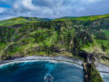 Aerial view of rugged cliffs meet the turbulent turquoise sea near Estrada do Farol Flores A&ccedil;ores Portugal.