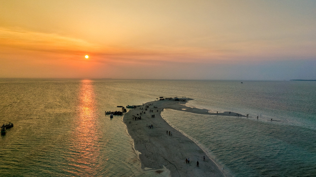 Aerial view of Gusung Sanggalau Sandbar a small sandy island surrounded by turquoise waters and coral reefs in Kecamatan Pulau Derawan Kalimantan Timur Indonesia. Aerial view of Gusung Sanggalau Sandbar a small sandy island surrounded by turquoise waters and coral reefs in Kecamatan Pulau Derawan Kalimantan Timur Indonesia.