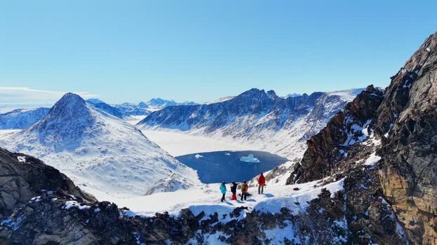 Aerial view of people on a snowy ridge in Tasiilaq Greenland. Aerial view of people on a snowy ridge in Tasiilaq Greenland.