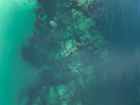 Aerial view of clear turquoise water and dark underwater rock formations at Vik Strand Leknes Nordland Norway. Aerial view of clear turquoise water and dark underwater rock formations at Vik Strand Leknes Nordland Norway.