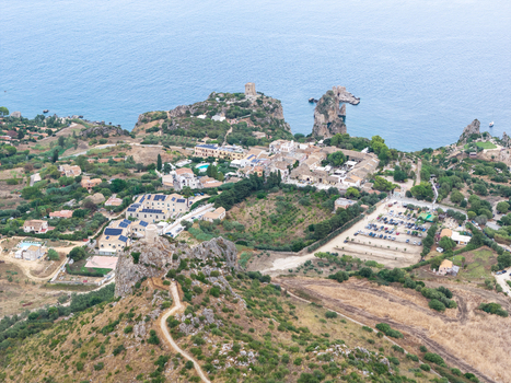 Aerial view of Riserva Naturale Orientata dello Zingaro featuring rugged coastal cliffs historic watchtowers Mediterranean vegetation and a parking area in San Vito Lo Capo Sicilia Italy. Aerial view of Riserva Naturale Orientata dello Zingaro featuring rugged coastal cliffs historic watchtowers Mediterranean vegetation and a parking area in San Vito Lo Capo Sicilia Italy.