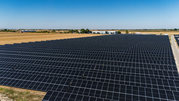 Aerial view of a large solar farm with rows of photovoltaic panels installed in a rural field under a clear blue sky in Temerin Vojvodina Serbia. Aerial view of a large solar farm with rows of photovoltaic panels installed in a rural field under a clear blue sky in Temerin Vojvodina Serbia.