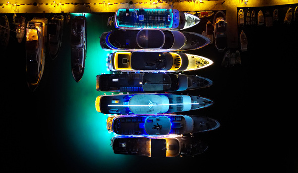 Aerial view of docked yachts illuminated with vibrant lights reflecting on the dark water creating a stunning contrast Hvar Croatia.