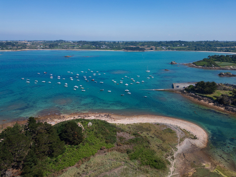 Aerial view of Plage de Port Blanc with numerous white boats anchored in turquoise waters near a small pier and sandy coastline in Penvenan Bretagne France. Aerial view of Plage de Port Blanc with numerous white boats anchored in turquoise waters near a small pier and sandy coastline in Penvenan Bretagne France.