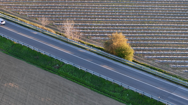 Aerial view of polytunnel fruit growing structures in the Po Valley landscape with a road and a car passing by Fiorenzuola d Arda Emilia Romagna Italy. Aerial view of polytunnel fruit growing structures in the Po Valley landscape with a road and a car passing by Fiorenzuola d Arda Emilia Romagna Italy.