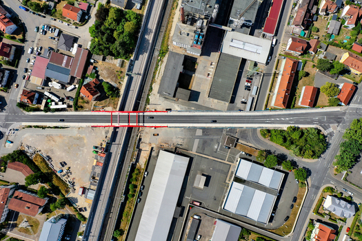 Aerial view of Piastenbrucke bridge with red railings crossing over railway tracks and industrial buildings in Forchheim Bayern Germany.