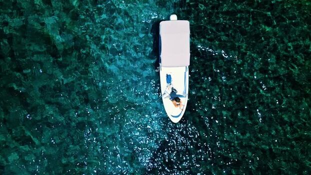 Aerial view of a boat on turquoise water in Guanaja Honduras. Aerial view of a boat on turquoise water in Guanaja Honduras.