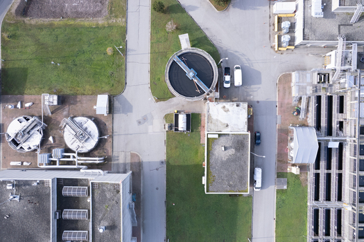 Aerial view of Waste Water Treatment facility with circular sedimentation tanks industrial buildings and paved access roads in Richmond British Columbia Canada. Aerial view of Waste Water Treatment facility with circular sedimentation tanks industrial buildings and paved access roads in Richmond British Columbia Canada.