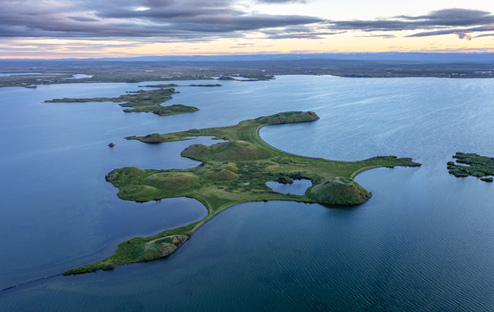 Aerial view of Lake Myvatn and the pseudocraters of Skutustadagigar surrounded by water and green landscape in Thingeyjarsveit Iceland.