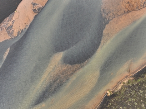 Aerial view of the meandering river with dark volcanic sand deposits and clear water currents in the landscape near Selfoss Sveitarfelagid Arborg Iceland. Aerial view of the meandering river with dark volcanic sand deposits and clear water currents in the landscape near Selfoss Sveitarfelagid Arborg Iceland.