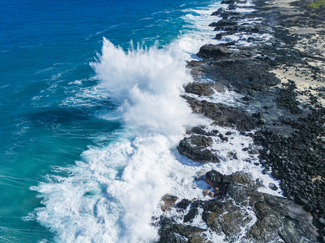 Aerial view of Kalaemamo coastline with powerful waves crashing against dark volcanic rocks and white sea spray Hawaii County Hawaii United States. Aerial view of Kalaemamo coastline with powerful waves crashing against dark volcanic rocks and white sea spray Hawaii County Hawaii United States.