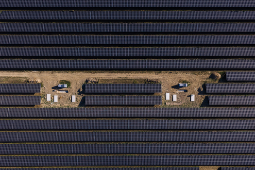 Aerial view of rows of solar panels in a large solar farm with dirt access paths and technical equipment in Uckermark Brandenburg Germany. Aerial view of rows of solar panels in a large solar farm with dirt access paths and technical equipment in Uckermark Brandenburg Germany.