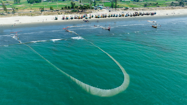 Aerial view of fishing boats casting nets in the shimmering turquoise waters a rhythmic dance between the sea and the shore Cox s Bazar Chittagong Division Bangladesh. Aerial view of fishing boats casting nets in the shimmering turquoise waters a rhythmic dance between the sea and the shore Cox s Bazar Chittagong Division Bangladesh.