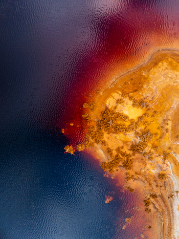 Aerial view of the vibrant red and orange acidic waters of a mineral rich tailing pond in Andalusia Spain. Aerial view of the vibrant red and orange acidic waters of a mineral rich tailing pond in Andalusia Spain.