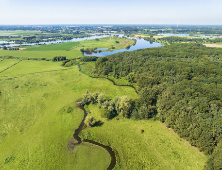 Aerial view of small meandering river Swalm in front of forest Donderberg and river Maas Swalmen Limburg Netherlands.