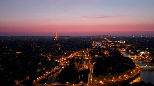 Aerial view of the Eiffel Tower and Notre Dame Cathedral illuminated at dusk in Paris Ile de France France. Aerial view of the Eiffel Tower and Notre Dame Cathedral illuminated at dusk in Paris Ile de France France.