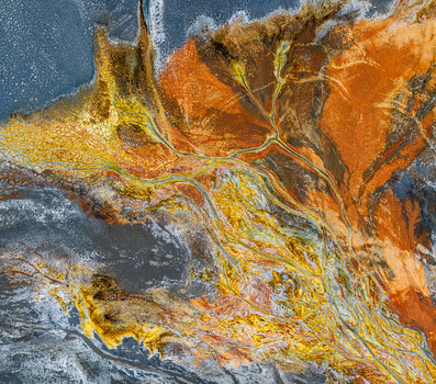Aerial view of the mineral rich landscape of Rio Tinto with vibrant orange yellow and red sediment patterns flowing through the terrain in Andalusia Spain. Aerial view of the mineral rich landscape of Rio Tinto with vibrant orange yellow and red sediment patterns flowing through the terrain in Andalusia Spain.