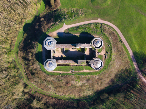 Aerial view of the stark imposing fortress of Stafford Castle its weathered stone walls contrasting with the vibrant green of the surrounding moat and parkland Stafford England United Kingdom. Aerial view of the stark imposing fortress of Stafford Castle its weathered stone walls contrasting with the vibrant green of the surrounding moat and parkland Stafford England United Kingdom.