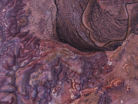 Aerial view of the colorful striated clay formations of the Bentonite Hills with a winding dry wash in the desert landscape of Hanksville Utah United States.