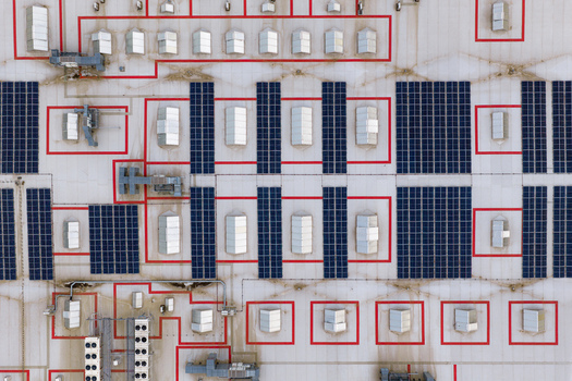 Aerial view of solar panels and red geometric markings on an industrial rooftop with ventilation units Breclav South Moravian Region Czechia.