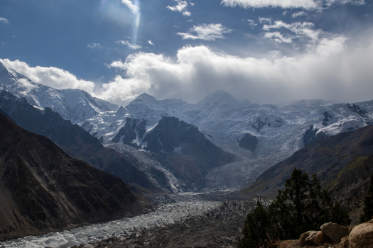 View of Nanga Parbat with its massive snow covered peaks glaciers and rocky slopes under a blue sky with clouds in Fairy Meadow Gilgit Pakistan. View of Nanga Parbat with its massive snow covered peaks glaciers and rocky slopes under a blue sky with clouds in Fairy Meadow Gilgit Pakistan.